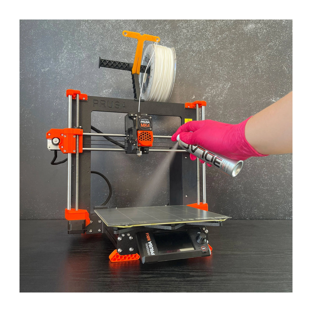 3DLAC MINI Spray 75 ml: Aufsprühen des Haftsprays auf die Bauplatte eines 3D-Druckers