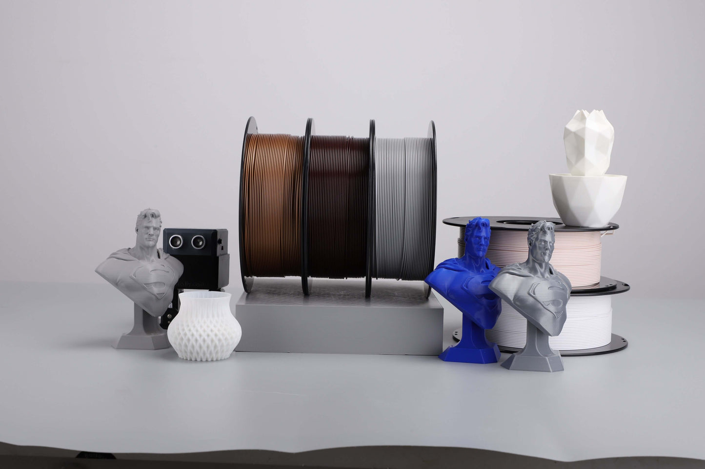 Kexcelled THE K5 PLA – Universelles FDM-Filament auf Spulen neben 3D-gedruckten Objekten, ideal für vielseitige Druckprojekte.
